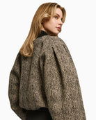 Side view of wool-blend cropped bomber showing puff sleeve and rhinestone detail