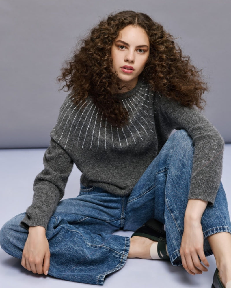 Model styling rhinestone knit blouse with smart black trousers