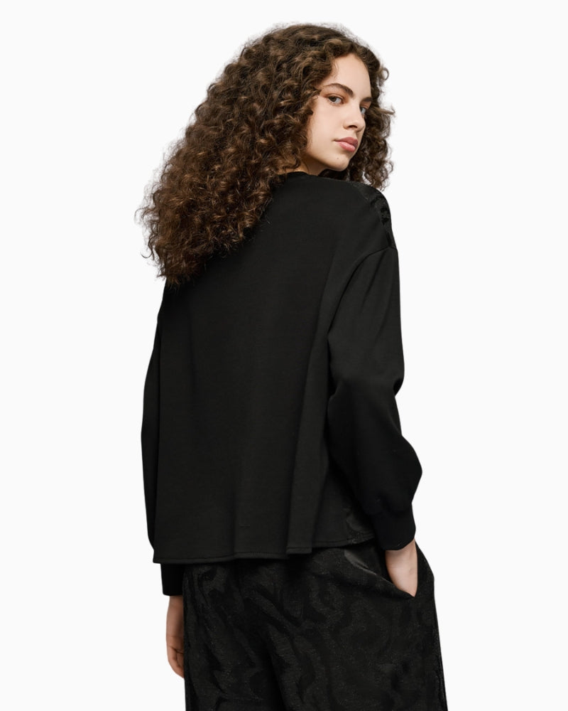 Back view of black jacquard blouse with clean finish and structure