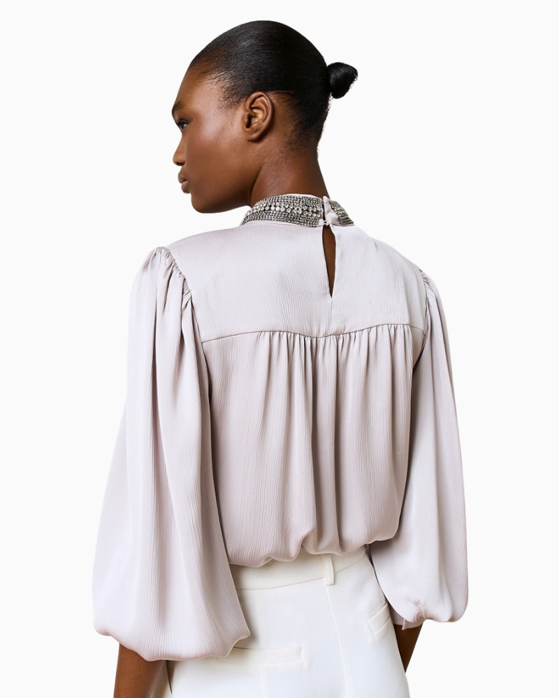 Back view of Silver Shimmery Blouse with button closure at neckline and smooth drape