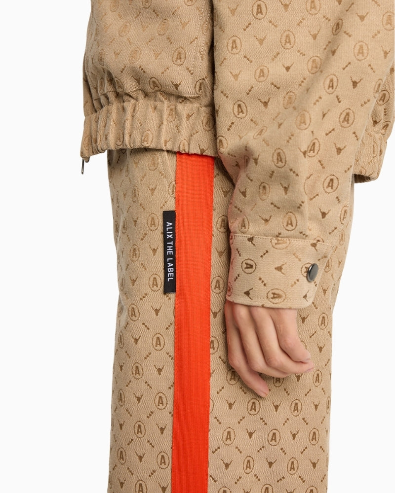Close-up of jacquard logo fabric and zip front on camel Alix jacket