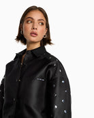 Close-up of ALIX artwork on chest pocket of cropped satin blouse