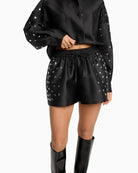 Close-up of stud detailing and satin texture on ALIX shorts