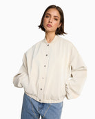 Model wearing cream ALIX bomber jacket with relaxed fit and pockets