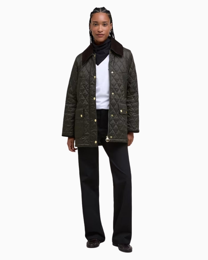 Women's black quilted Barbour jacket styled casually with jeans and boots