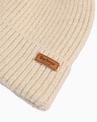 Close-up of Barbour beige knitted beanie with logo badge