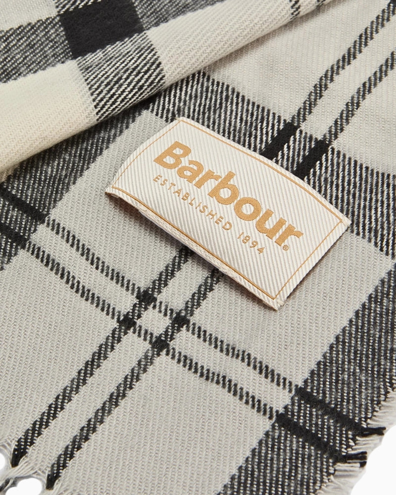 Angled view of monochrome tartan scarf showing brand label