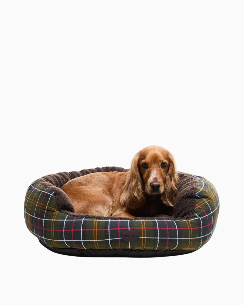 Dog resting in Barbour Snuggle Dog Bed with tartan trim and fleece lining