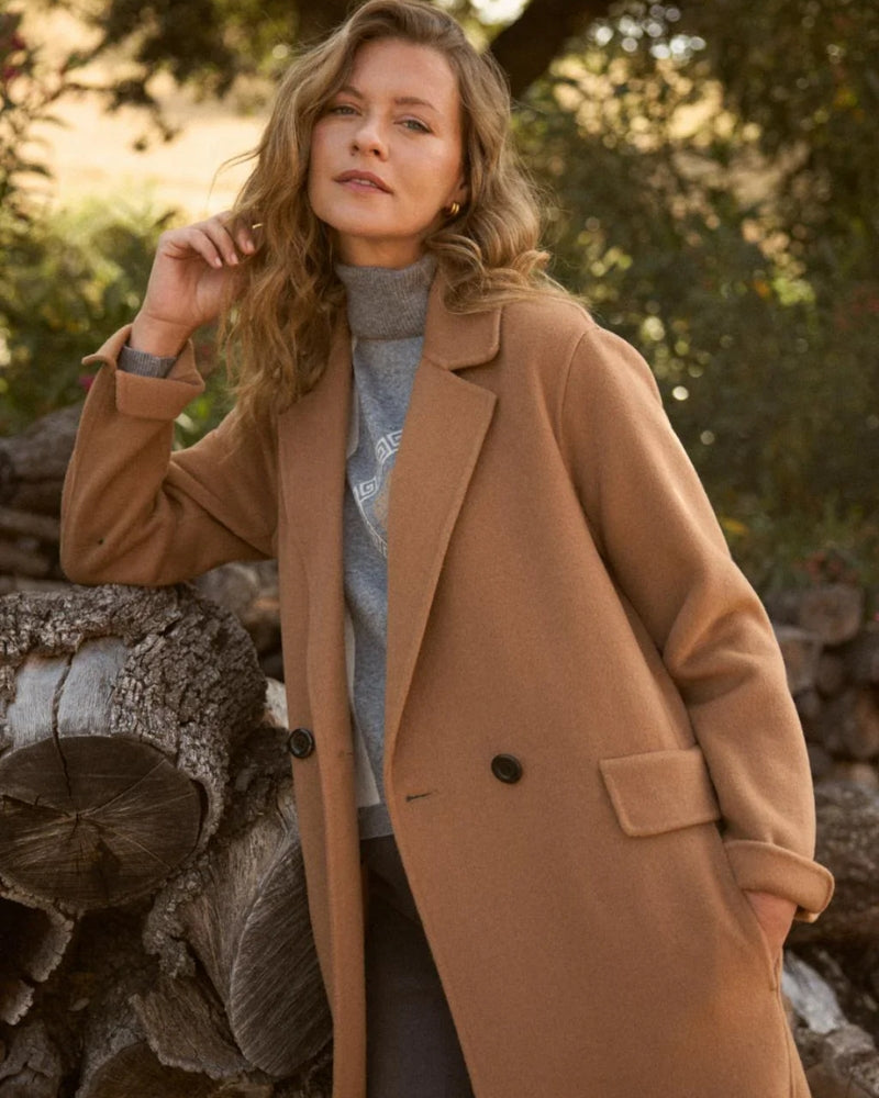 Model wearing Bariloche camel coat over knit and jeans
