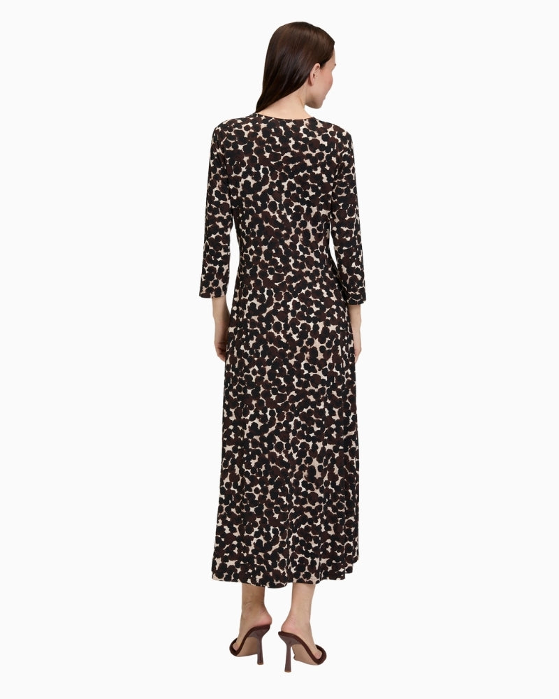 Back view of close-fitting jersey midi dress showing soft drape and dot print
