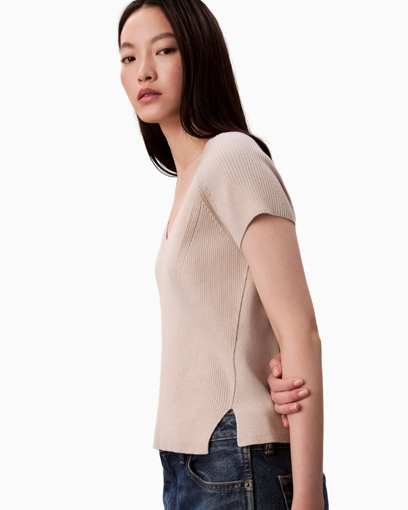 Side profile of off-white sleeveless crew neck sweater by CK Jeans