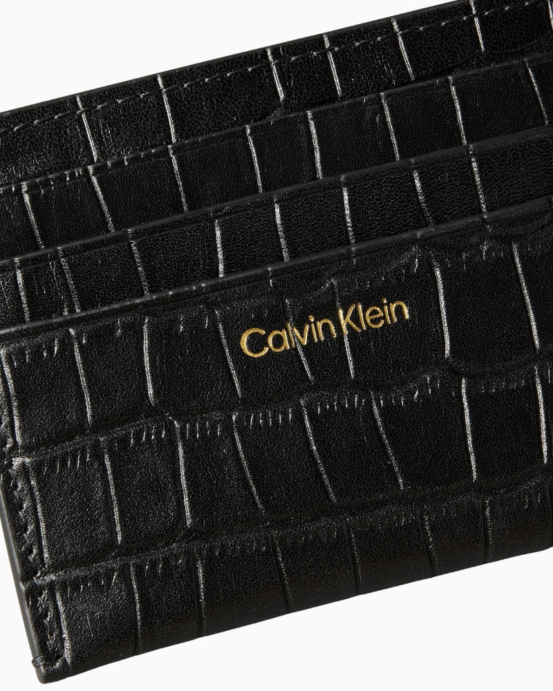 Close‑up of croc pattern detail and CK logo edge on wallet