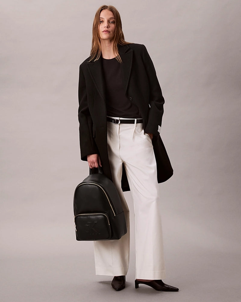 Model of Calvin Klein faux leather backpack with embossed logo
