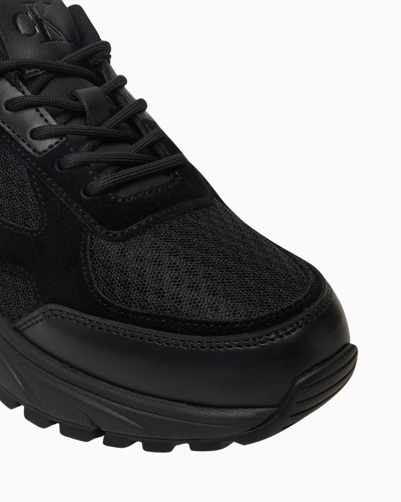 Close up view of lace-up trainers with chunky black sole