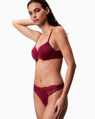 Side view of Flat lay of CK thong in soft pink polypropylene blend with logo detail