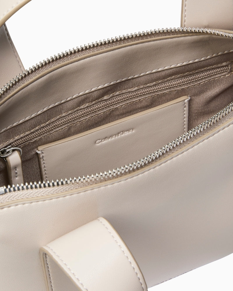 Close‑up of croc pattern detail and CK logo edge on wallet