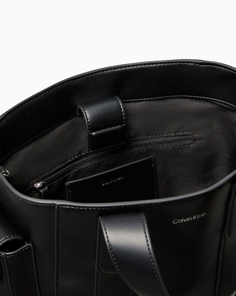 Close-up of webbing strap attachment and neat stitching on black Calvin Klein tote