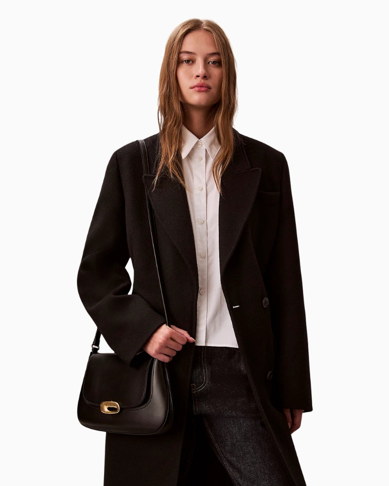 Woman wearing Calvin Klein engraved medium flap crossbody bag black crossbody fit – Áines Boutique