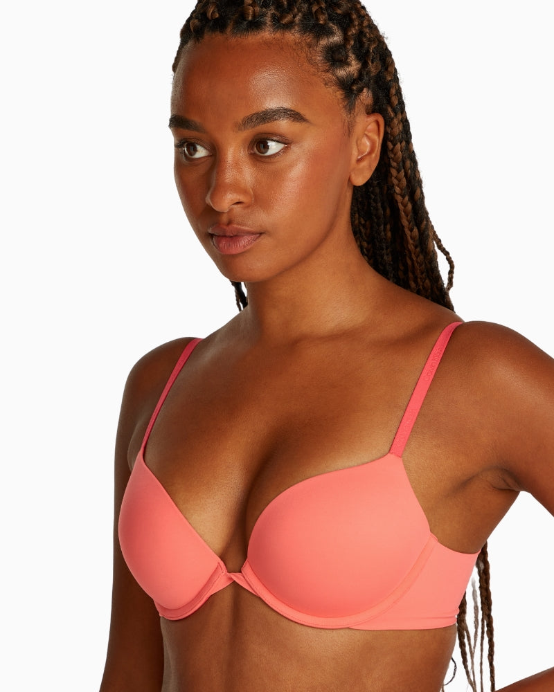 Model wearing Calvin Klein exquisite pink plunge bra showing deep neckline
