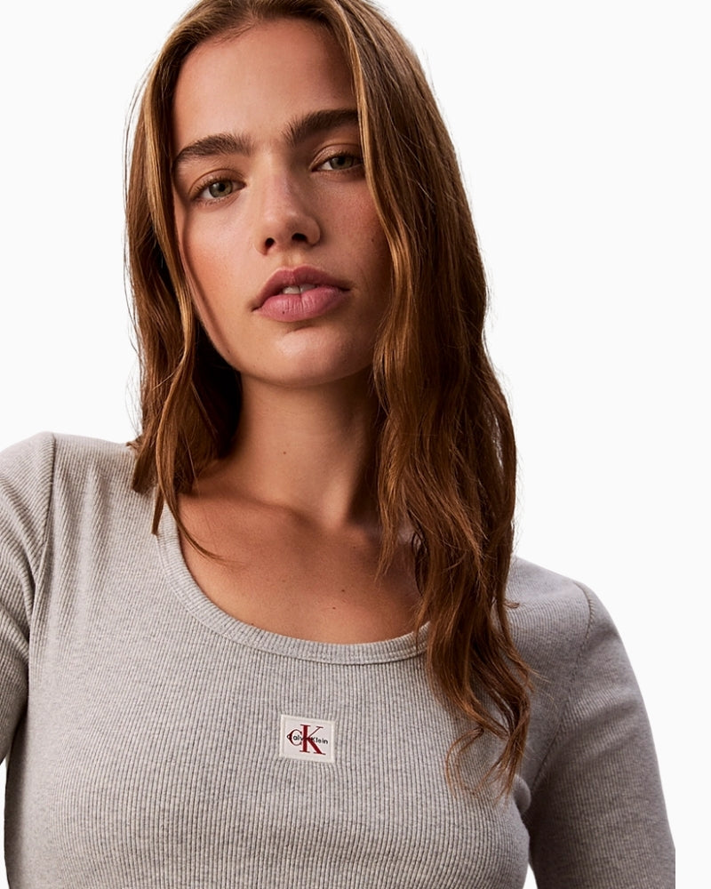 Close-up of fine rib texture and Calvin Klein badge on stretch cotton fabric