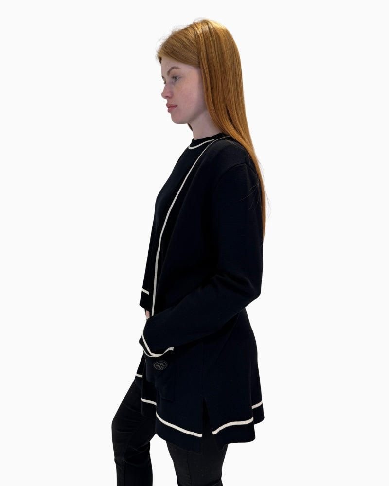 Side profile of the black cardigan showing the relaxed fit, side slits, and trim detail