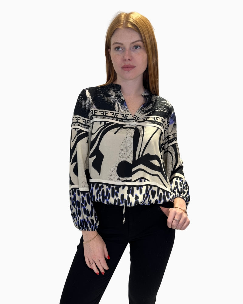 Front view of Faber Woman printed V-neck blouse showing mixed abstract patterns and ruffled collar