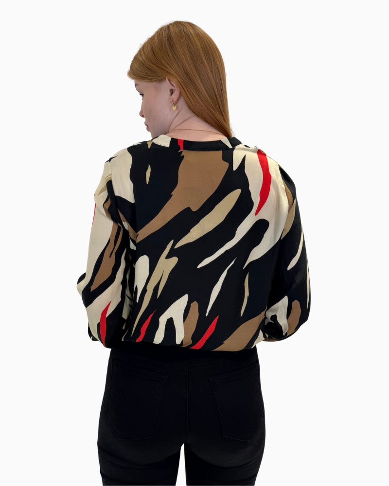 Back view of the V-neck blouse showing the full abstract print and elasticated hem