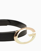 Close-up of gold-tone buckle on black Guess belt in faux leather