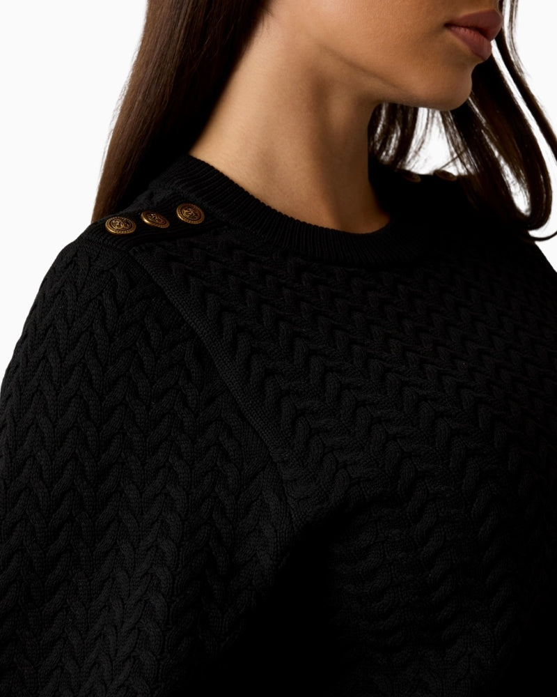 Shoulder detail on cable knit jumper featuring decorative buttons
