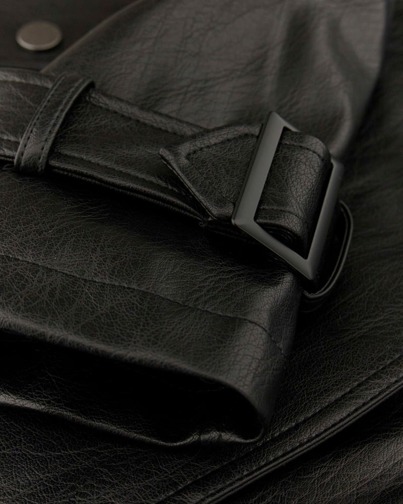 Close-up of snap flap pocket and matte faux leather texture on GUESS trench coat