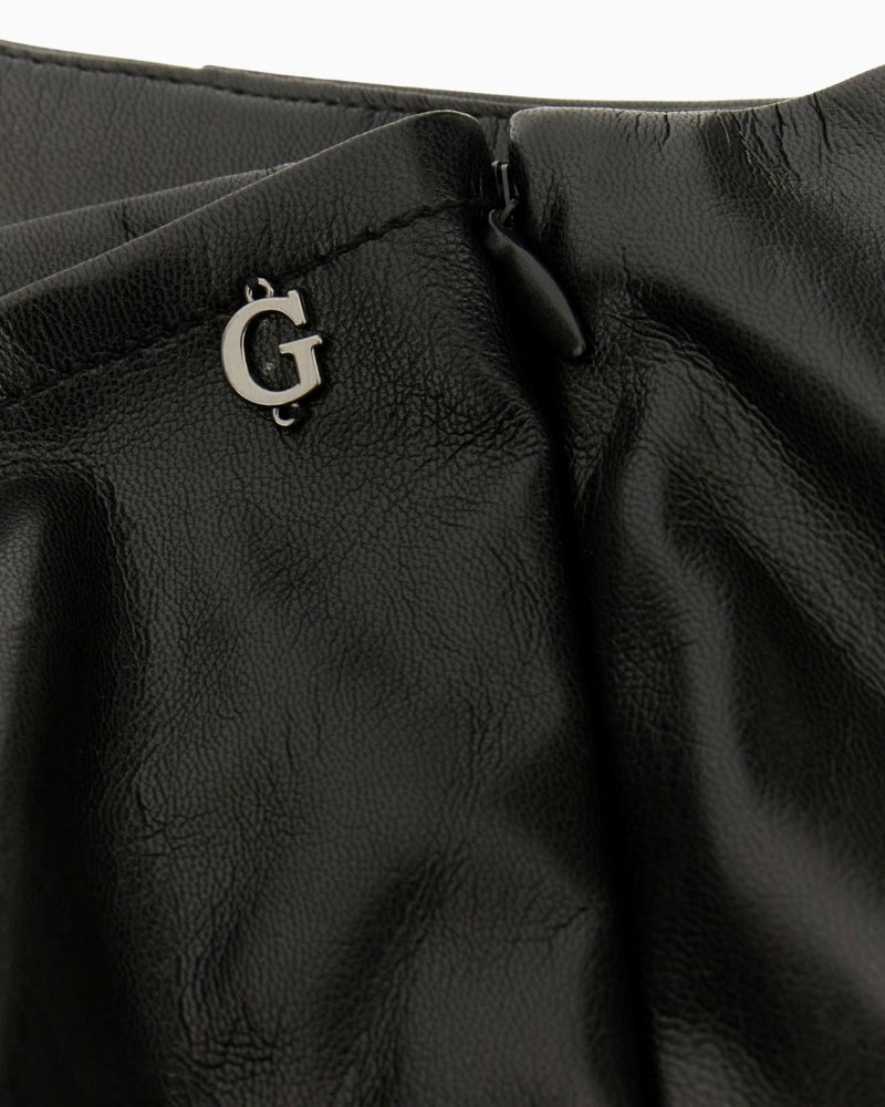 Close‑up of faux leather texture and bow embellishment on Guess mini skirt