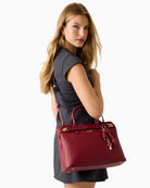 Front view of structured red handbag with twin handles and zip closure