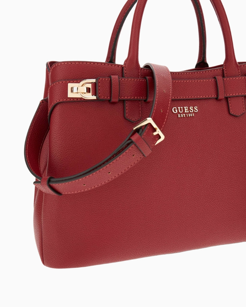 Close-up of detachable charm and Guess logo on red handbag