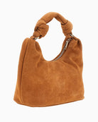 Side view of suede handbag showing soft structure and triangle logo