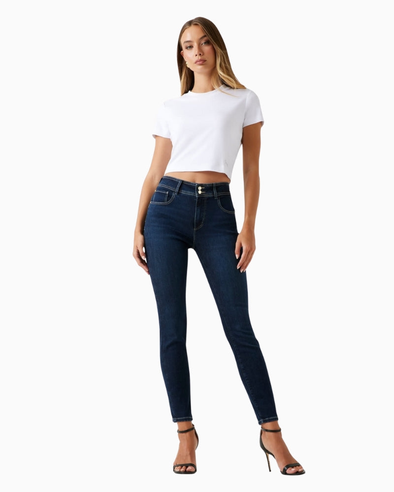 Skinny leg Guess jeans styled with heels and blouse for a smart look