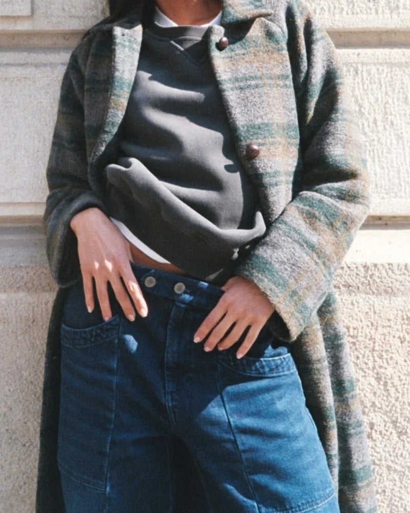 Close up view of mid-rise jeans with double-button waist and large pockets