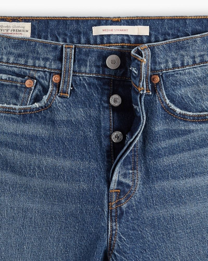 Close up view of Straight leg high-rise jeans by Levi’s in faded blue stretch denim with button fly