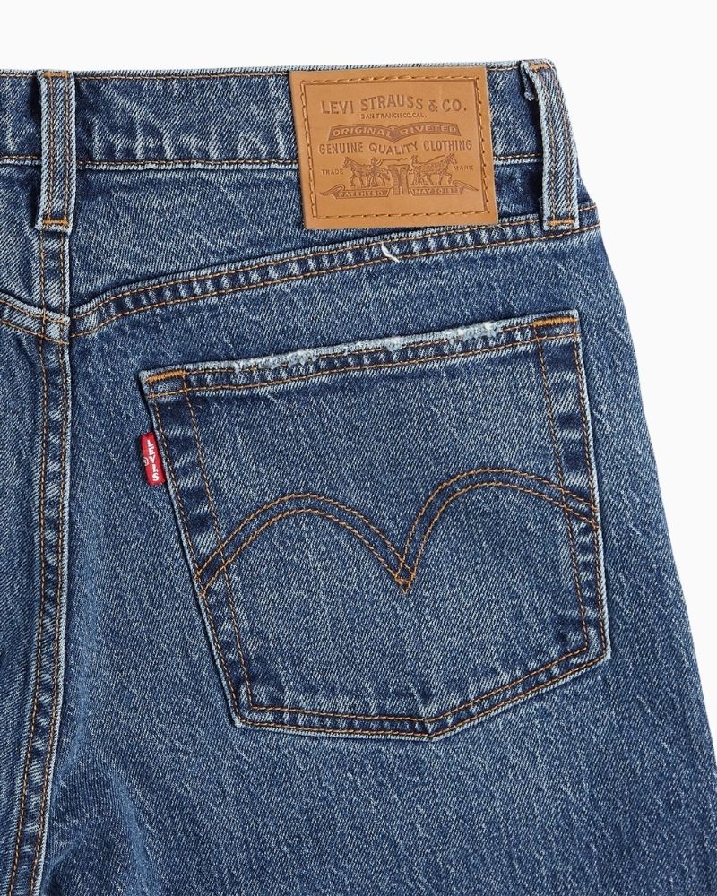 Close up view of Straight leg high-rise jeans by Levi’s in faded blue stretch denim with button fly
