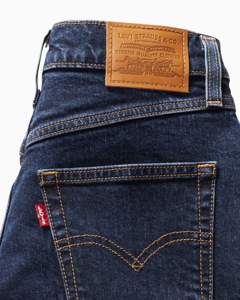Close up view Levi’s 80s Mom jeans in mid-blue stretch denim with tapered leg and high-rise waist
