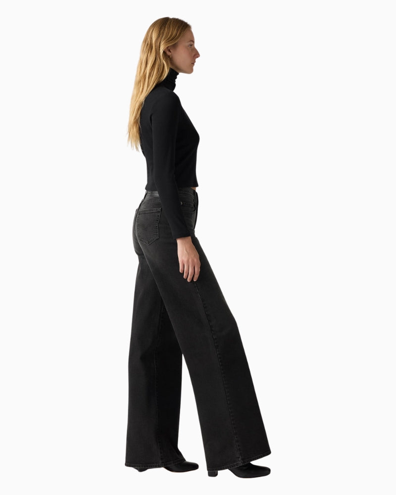 Side angle showing slim hip and relaxed thigh on Levi’s 728 wide-leg jeans