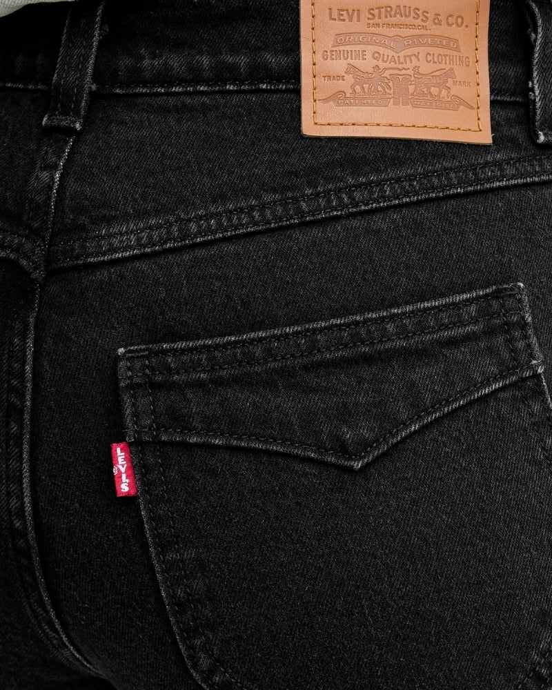 Close-up of waistline and button closure on Levi’s Wedgie Boot Piping jeans