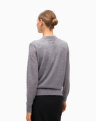 Back view of knit sweater showing button closure and smooth finish