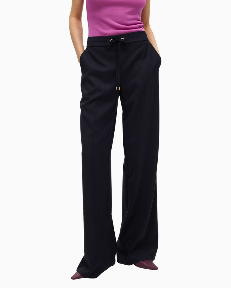 Front view of Lola Casademunt pinstripe trousers with gold detail and elastic waist