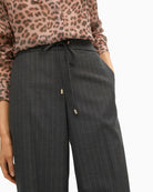 Close-up of high waist and metallic button closure on stretch denim