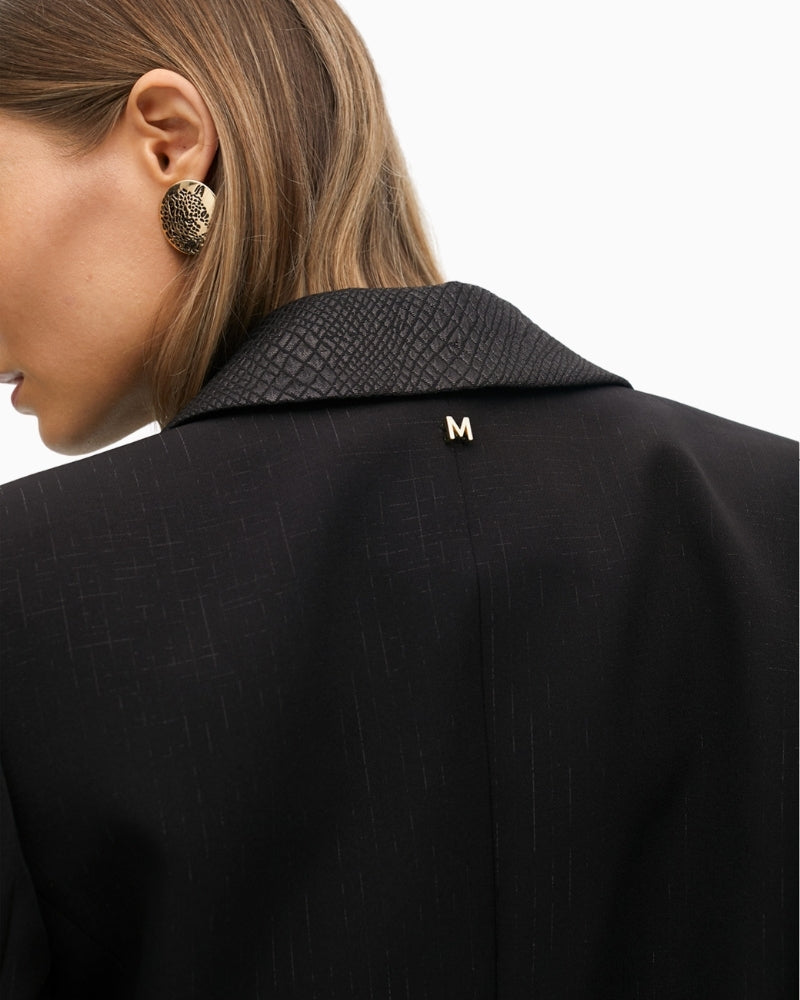 Close up of Cropped structured jacket with bold lapel and tailored shape