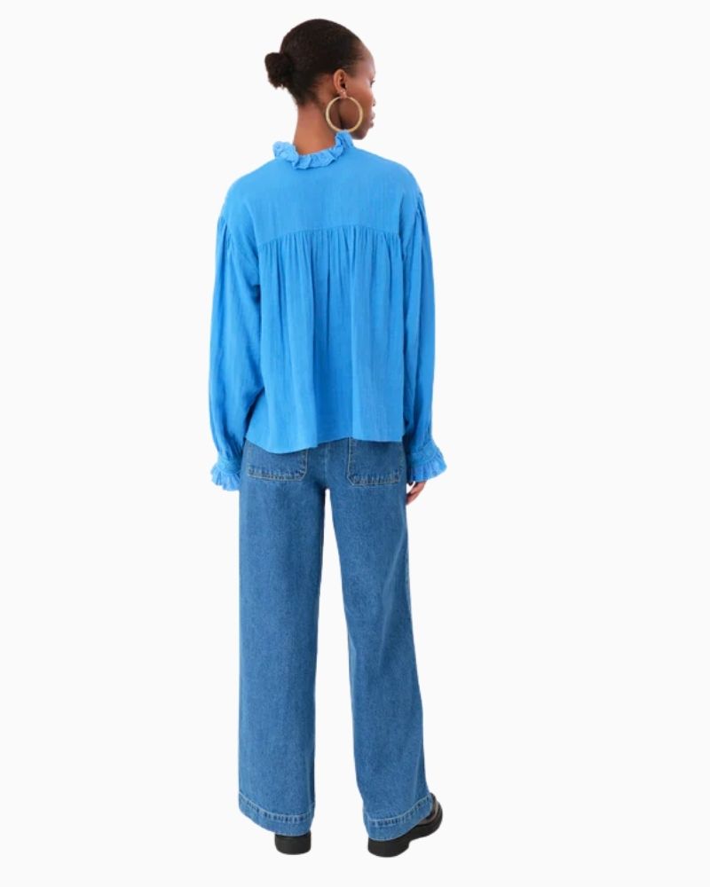 Back of blue blouse showing broderie anglaise yoke and ruffled cuff detail