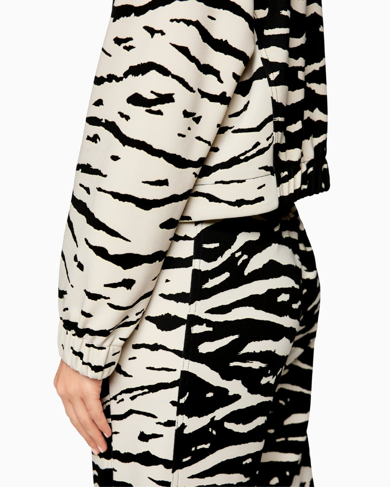 Close-up of ribbed knit collar and subtle animal pattern on black fabric