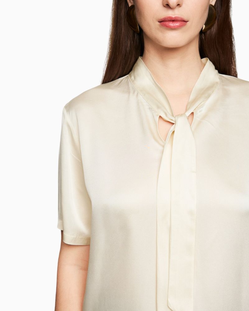 Close-up of silk fabric and feminine tie detail at the neck