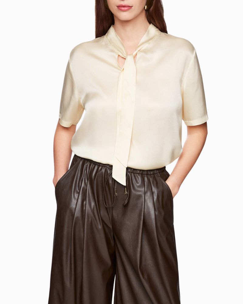 Close-up of silk fabric and feminine tie detail at the neck