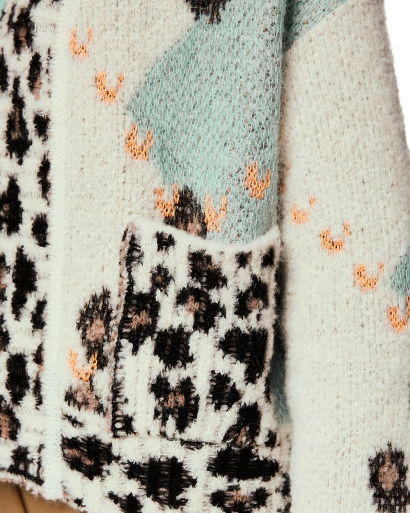 Close-up of soft chunky knit showing leopard detail at cuffs and lapels